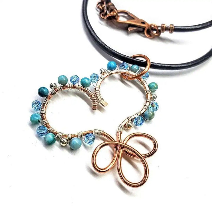 Wire Wrapped Copper Turquoise Heart Infinity Charm Necklace featuring a copper heart with turquoise beads and crystals.
