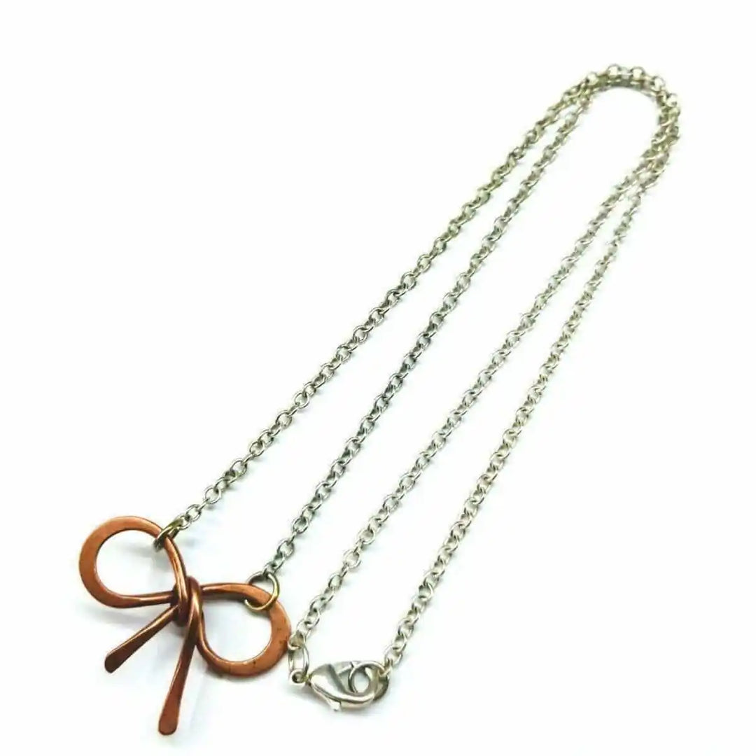 Wire Wrapped Copper Bow Tie Silver Chain Necklace showcasing a copper bow tie pendant on a silver chain.