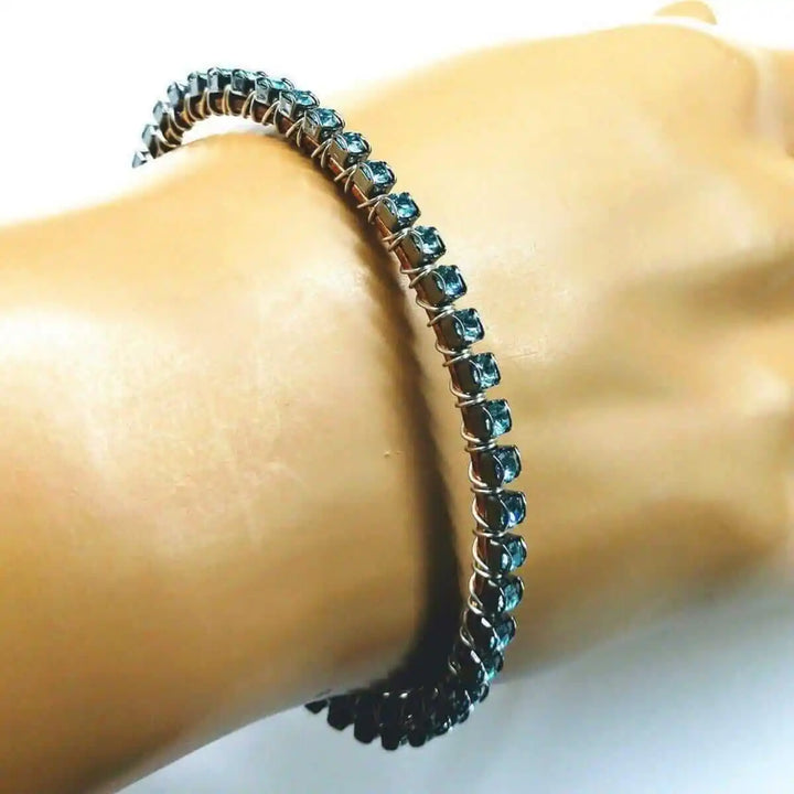Wire Wrapped Turquoise Crystal Tennis Bangle Bracelet on a hand, featuring aqua blue Swarovski-quality crystals.