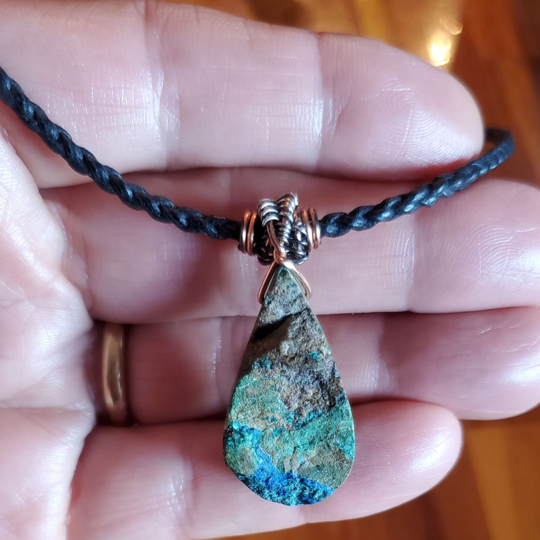 My hand is holding a Wire Wrapped Natural Cut Azurite Malachite Drop Necklace