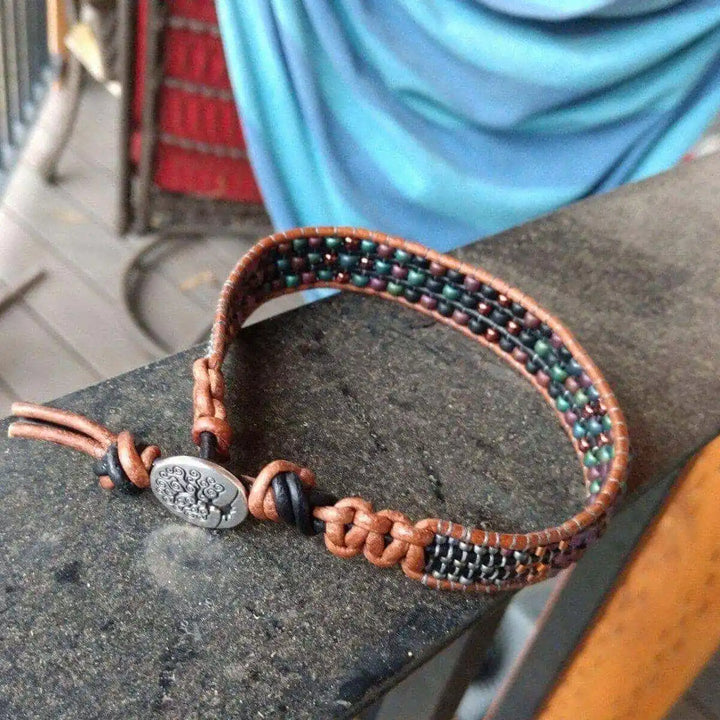 X-Large Leather Intricate Beaded Tree Of Life Bracelet displayed on a textured surface with braided designs.