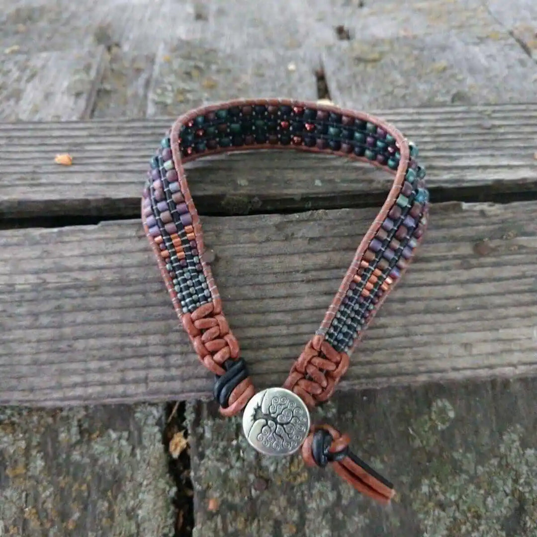 X-Large Leather Intricate Beaded Tree Of Life Bracelet showcased on a rustic wooden surface, featuring unique beadwork and leather.