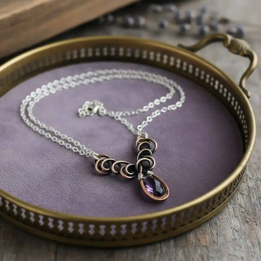 Silver and Copper Wire Sculpted Purple Crystal Drop Necklace displayed on a decorative tray with purple velvet.