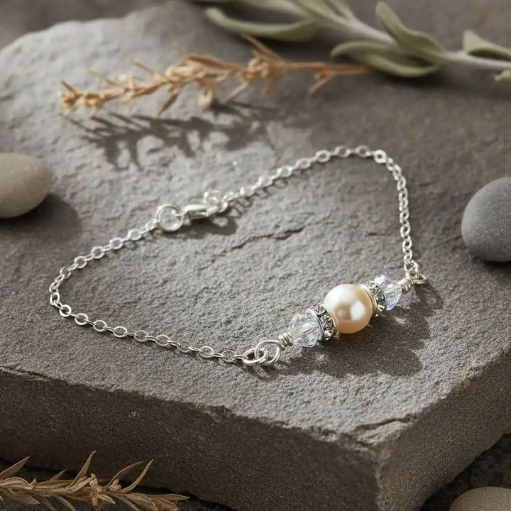Silver Swarovski Crystal Pearl Bar Bridal Bracelet displayed on a stone background, showcasing its elegance and detail.