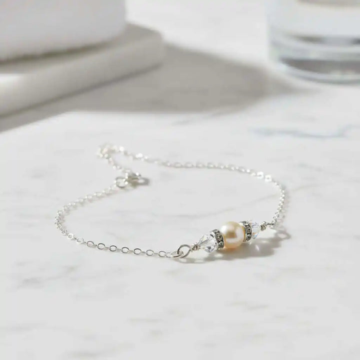 Silver Swarovski Crystal Pearl Bar Bridal Bracelet displayed on a marble surface, showcasing elegance and sophistication.