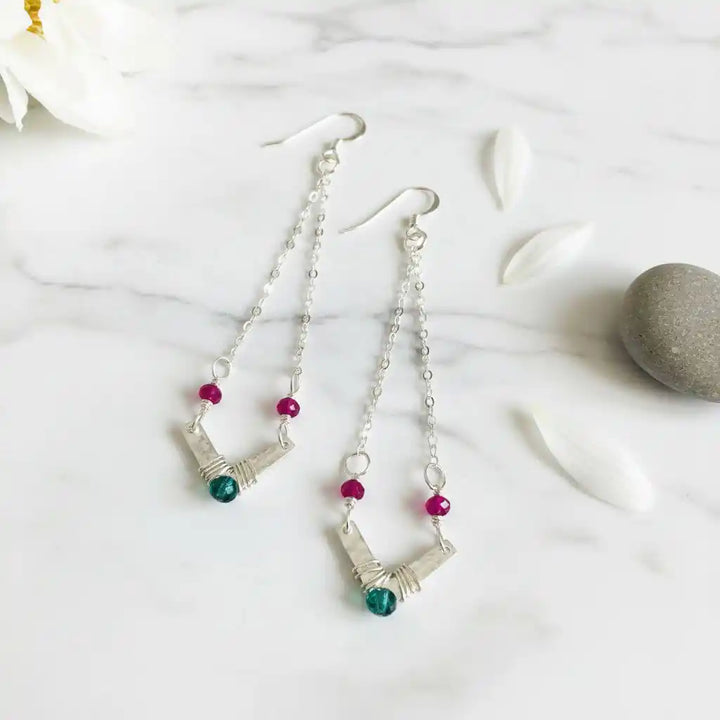 Sterling Silver Chevron Hot Pink Green Gemstone Earrings on a marble surface with petals and a stone.