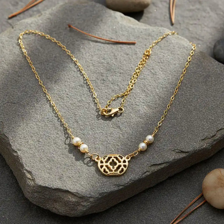 As Seen on Molly Ringwald Gold Filled Pearl Choker Necklace featuring gold chain and pearl accents on a stone background.