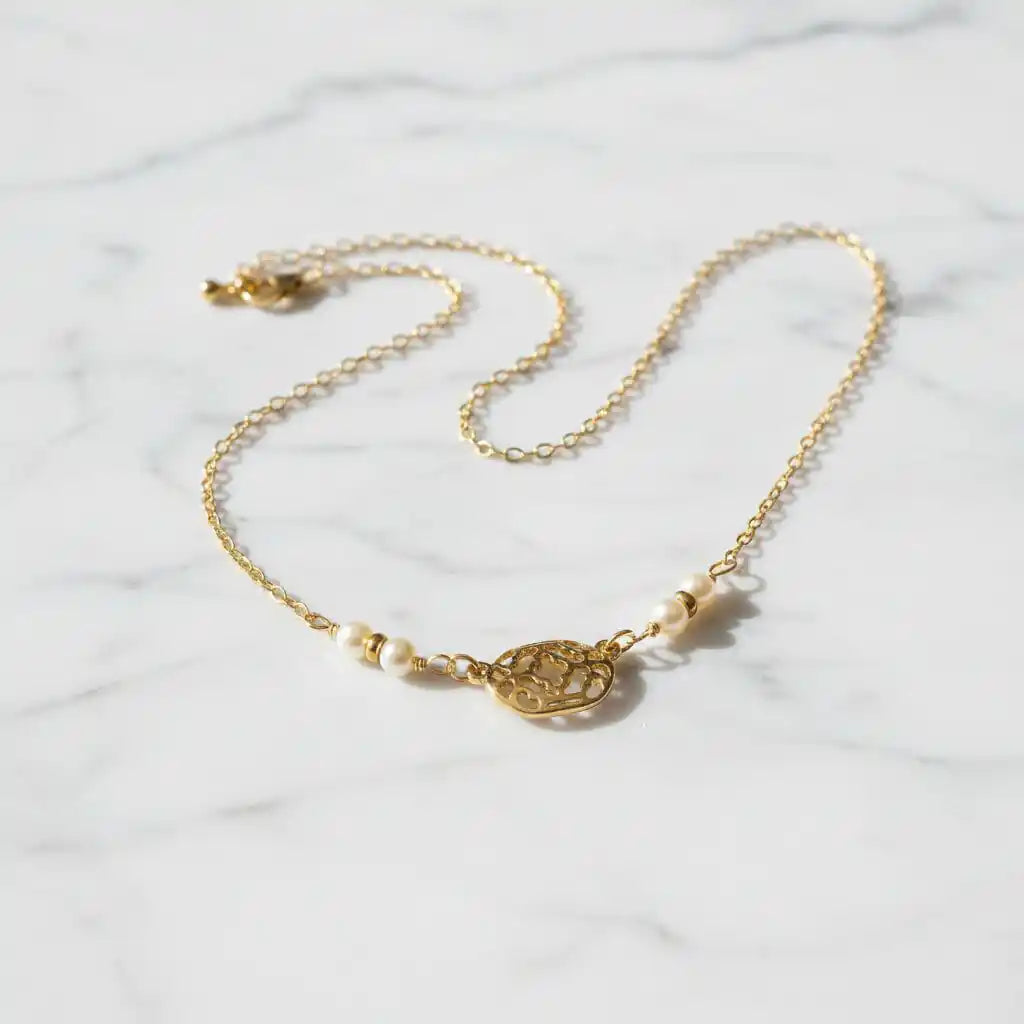 As Seen on Molly Ringwald Gold Filled Pearl Choker Necklace on a marble surface, featuring a delicate design.