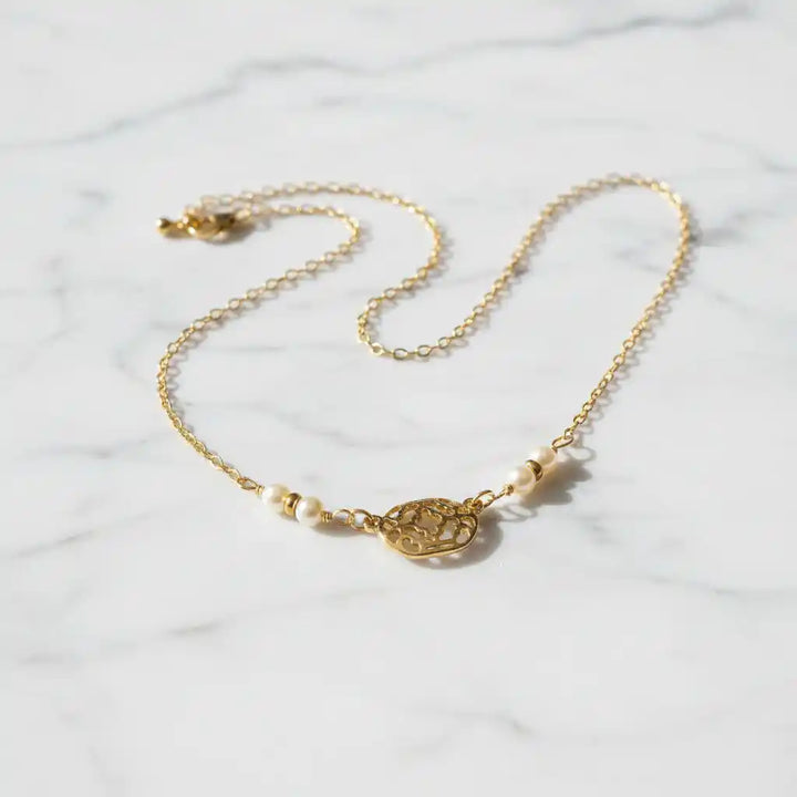 As Seen on Molly Ringwald Gold Filled Pearl Choker Necklace on a marble surface, featuring a delicate design.