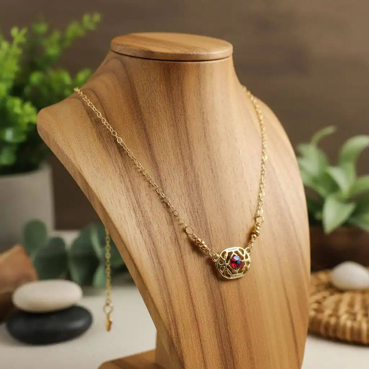 Red Crystal 14 K Gold Filled Adjustable Filigree Choker displayed on a wooden necklace stand with a blurred background.
