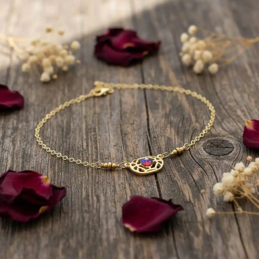 Red Crystal 14 K Gold Filled Adjustable Filigree Choker displayed on rustic wood with rose petals.