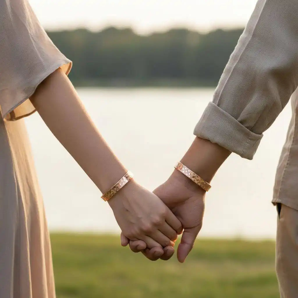 His and Her Copper Embossed Weave Cuffs 16 Gauge worn by a couple holding hands outdoors.