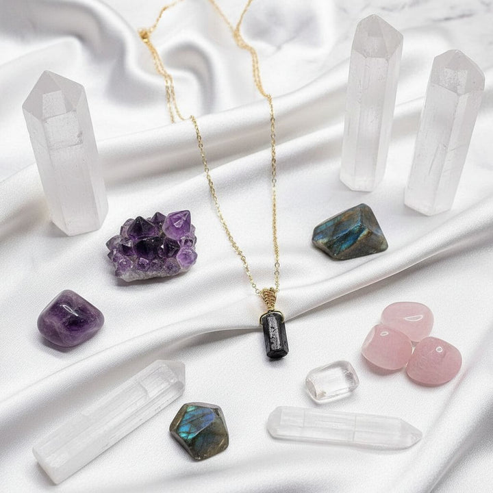 Wire Wrapped Raw Black Tourmaline Gemstone Necklace displayed with various crystals on satin fabric.