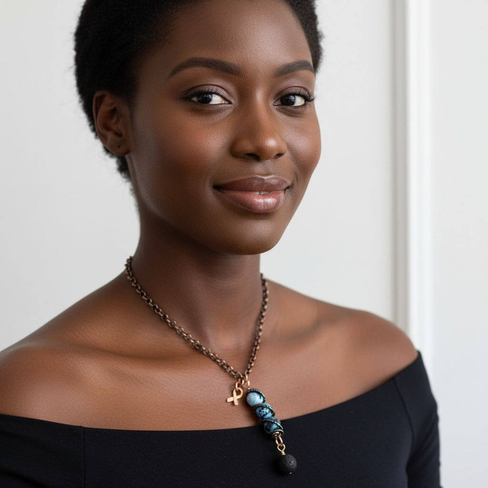 Model wearing Child Abuse Awareness Agate Necklace With Lava Rock Bead showcasing the copper spiral pendant and blue agate beads.