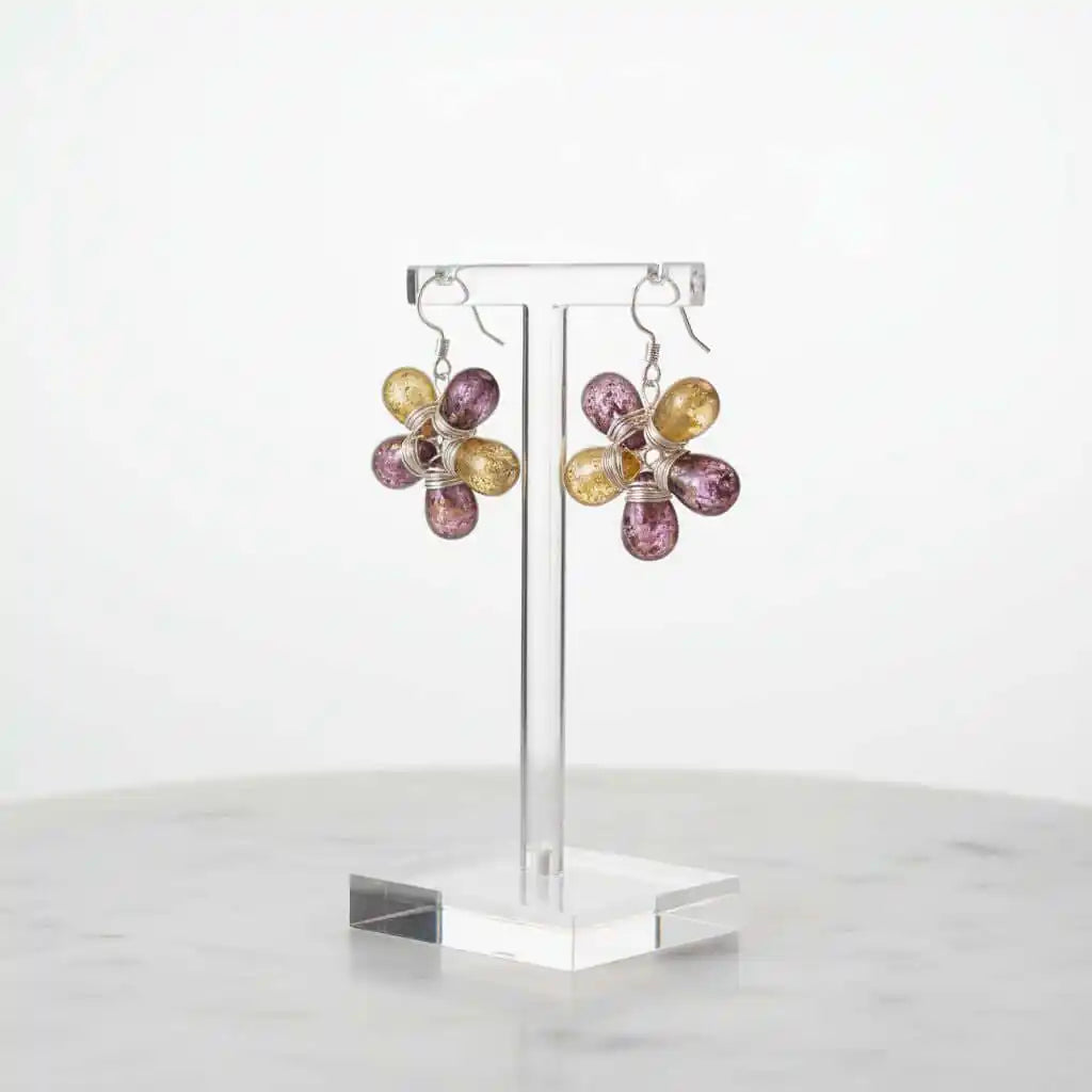 Purple and Yellow Flower Sterling Silver Earrings displayed on a stand, showcasing their floral design and colorful glass beads.