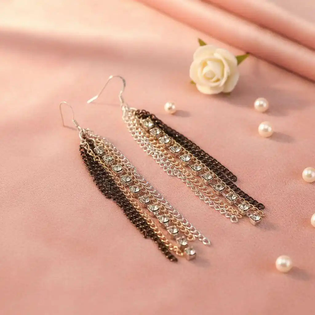 Rhinestone Crystal Chain Fringe Earrings displayed on soft fabric with decor, showcasing elegant cascading chains and crystals.