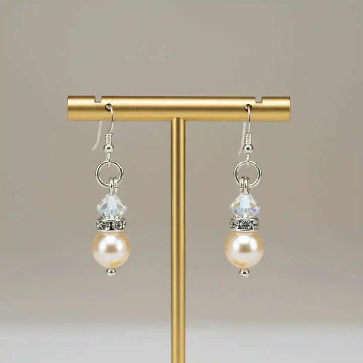 Various Color Swarovski Crystal Pearl Stack Earrings displayed on a stand with elegant design.