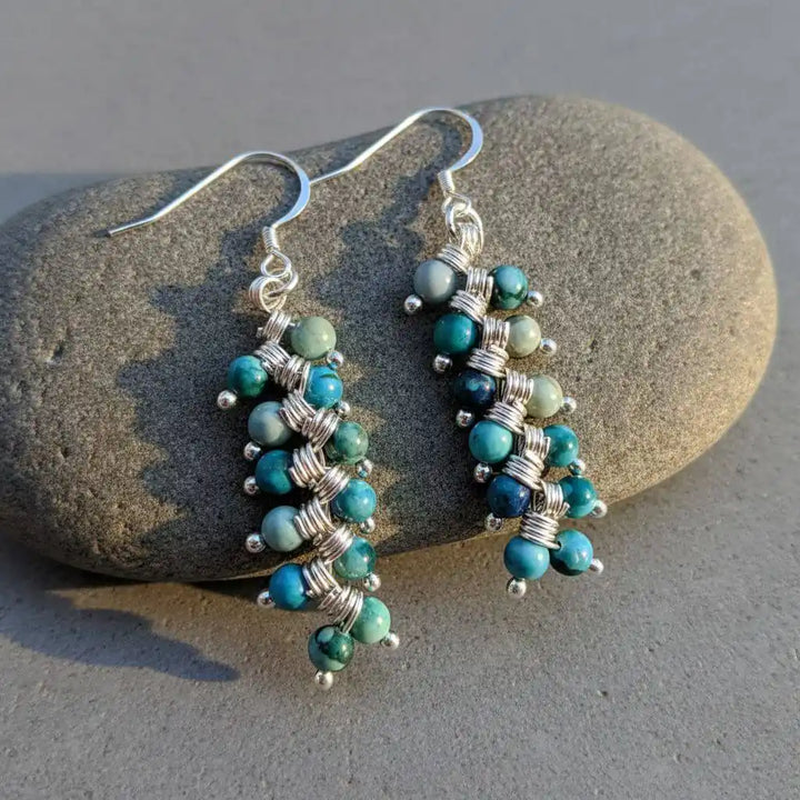 Seen On Jane The Virgin Silver Turquoise Wire Coil Earrings displayed on a smooth stone background.