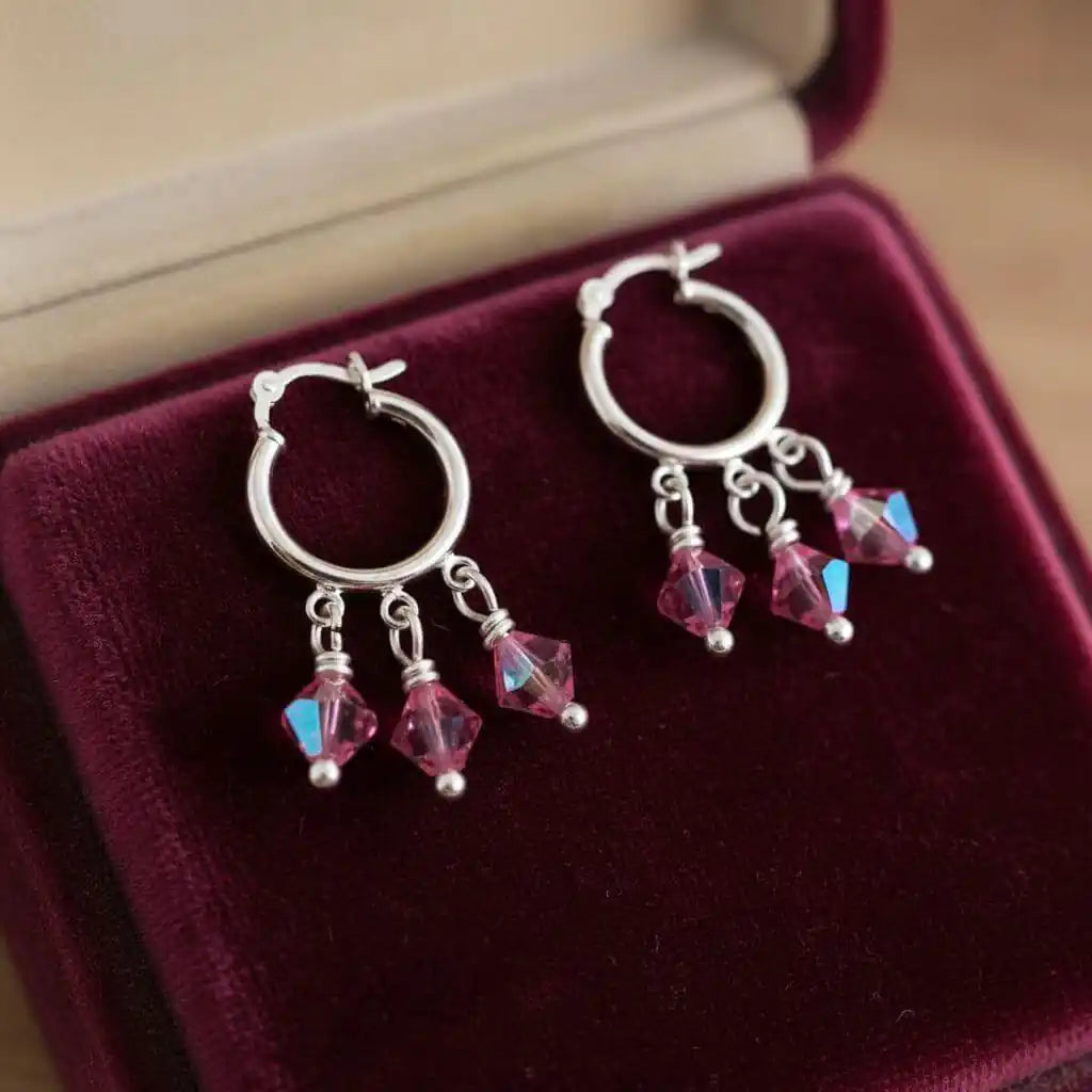 Mini Sterling Silver Hoop Pink Crystal Dangle Earrings displayed on a velvet jewelry box.