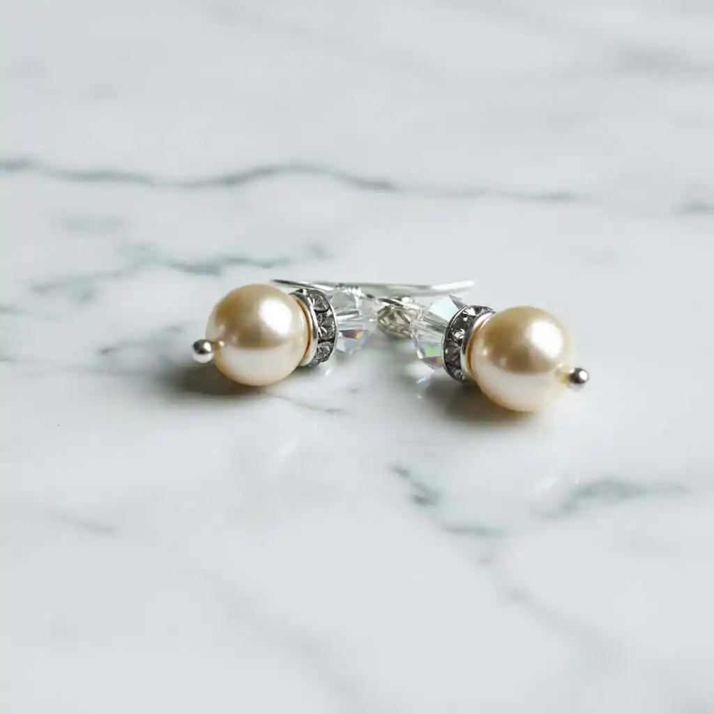 Various Color Swarovski Crystal Pearl Stack Earrings on a marble surface, showcasing elegance and sophistication.