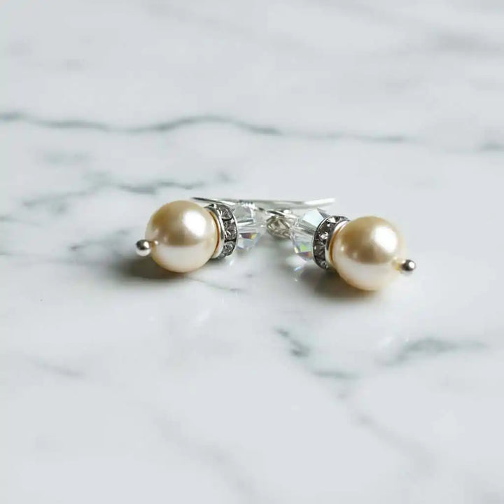 Various Color Swarovski Crystal Pearl Stack Earrings on a marble surface, showcasing elegance and sophistication.