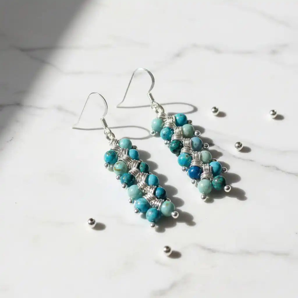 Seen On Jane The Virgin Silver Turquoise Wire Coil Earrings featuring turquoise beads on a marble background.