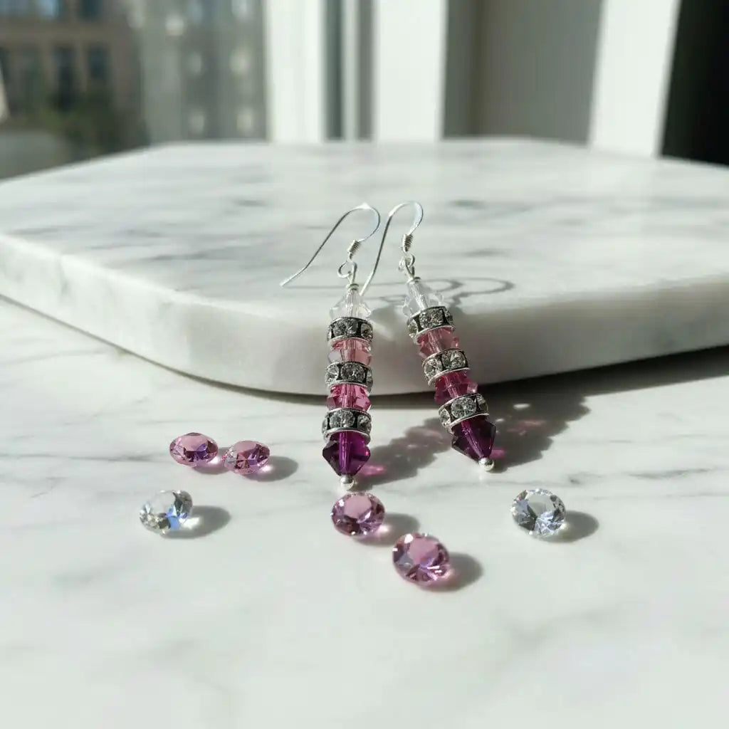 Hot Pink Ombre Stacked Crystal Sterling Silver Earrings alongside loose Swarovski crystals on a marble surface.