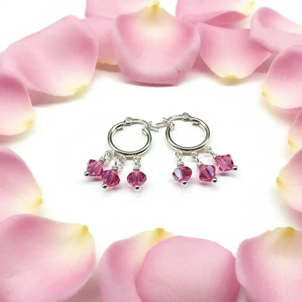 Mini Sterling Silver Hoop Pink Crystal Dangle Earrings surrounded by pink rose petals.