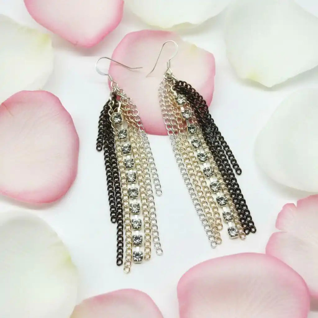 Rhinestone Crystal Chain Fringe Earrings with cascading chains and rhinestones on rose petal background.