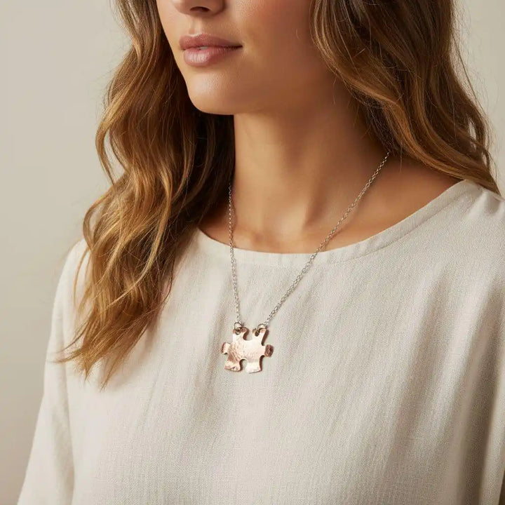 Necklace with a puzzle piece pendant worn by a person against a neutral background