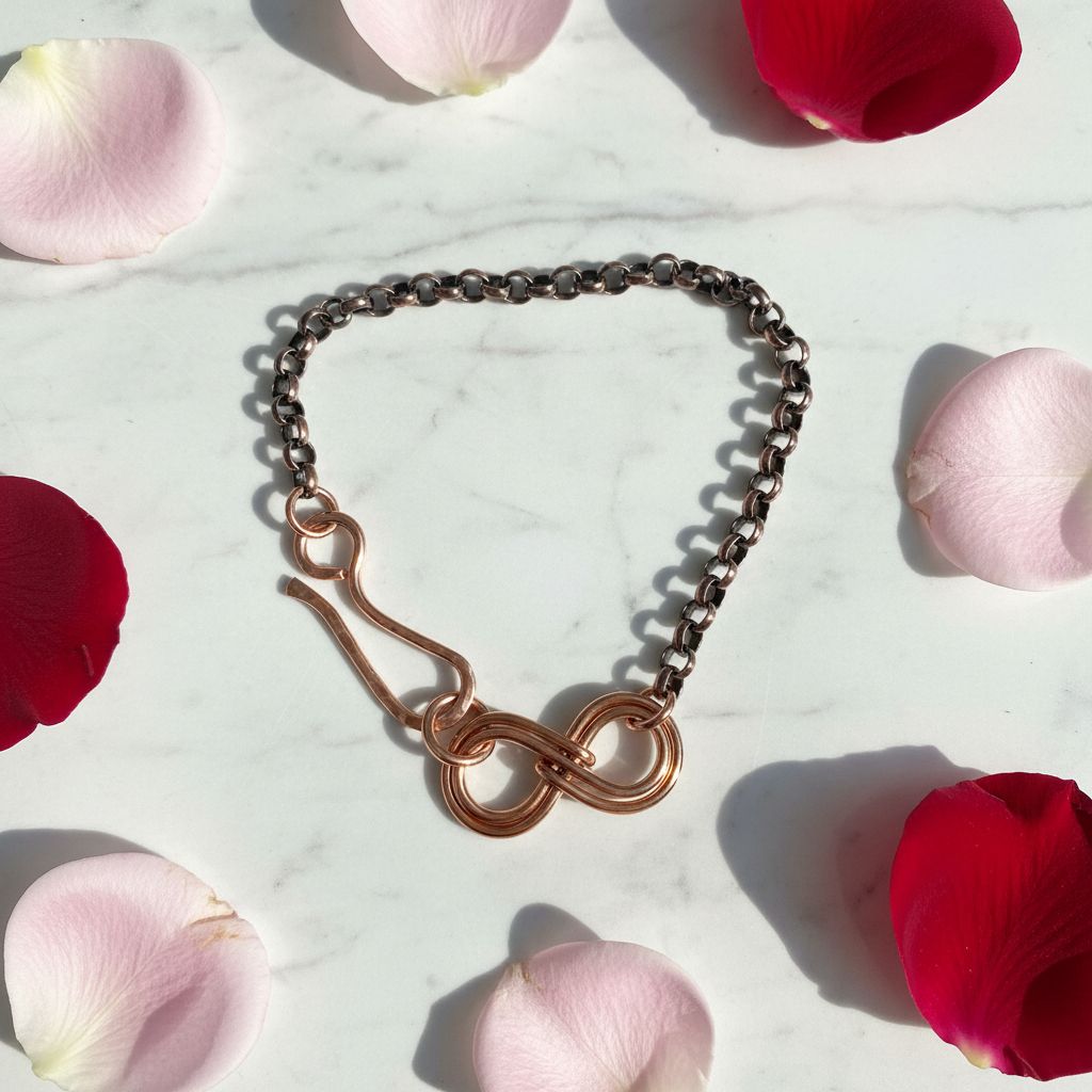 Wire Sculpted Copper Double Infinity Chain Bracelet surrounded by rose petals.