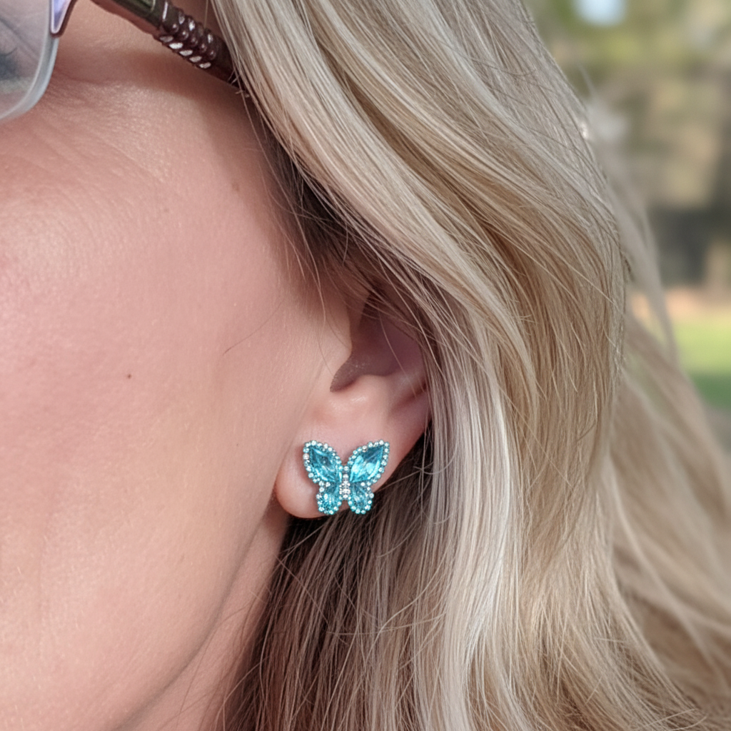 Woman wearing aquamarine butterfly stud earrings