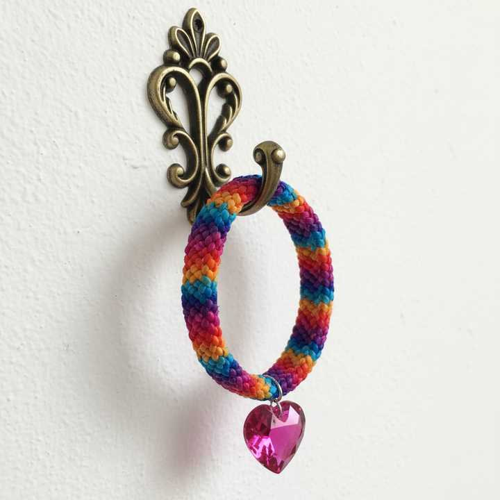 Tie-dye macrame bracelet hanging on brass jewelry hook