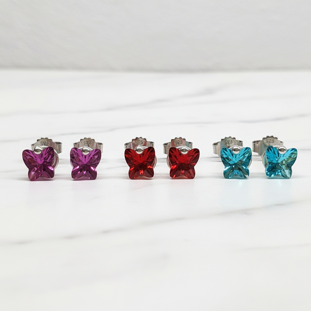 Butterfly stud earrings in all three colors on marble