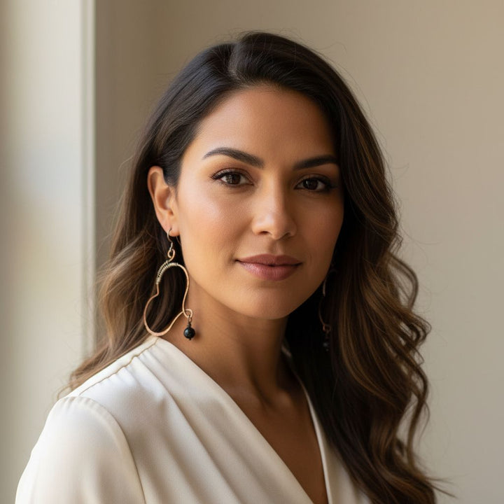 Model wearing Sculpted Copper Butterfly Wing Abuse Survivor Earrings with black Swarovski crystal dangles.