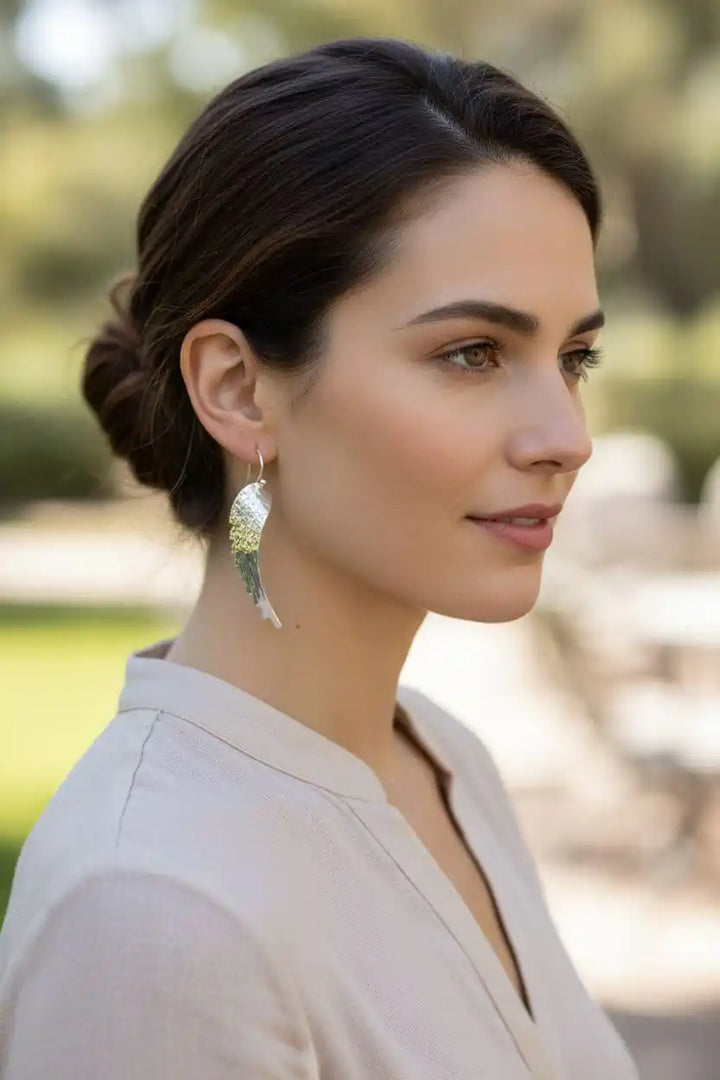 Silver Hammered Sculpted Angel Wing Earrings showcased on a model outdoors, highlighting their unique hammered design.