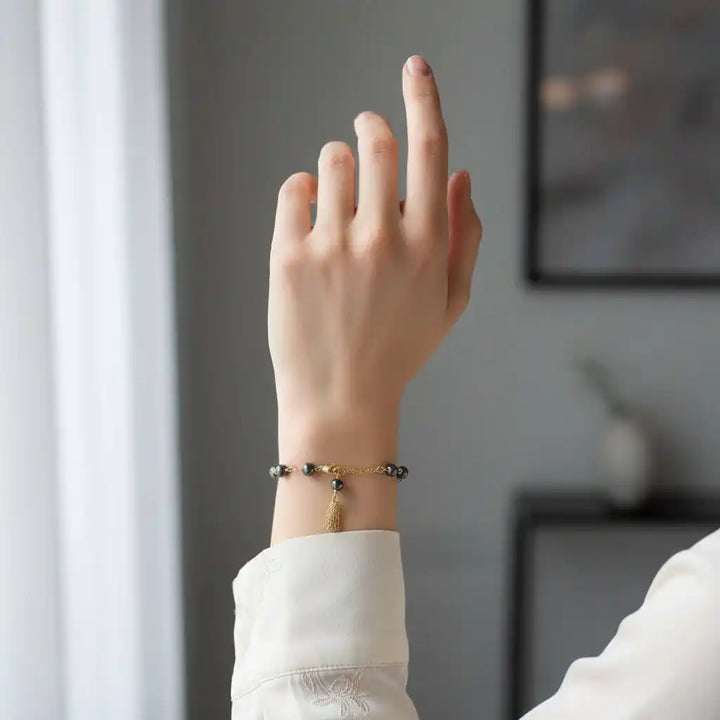Adjustable 14 KT Gold Filled Hematite Chain Tassel Bracelet worn on a hand, showcasing its elegant design.