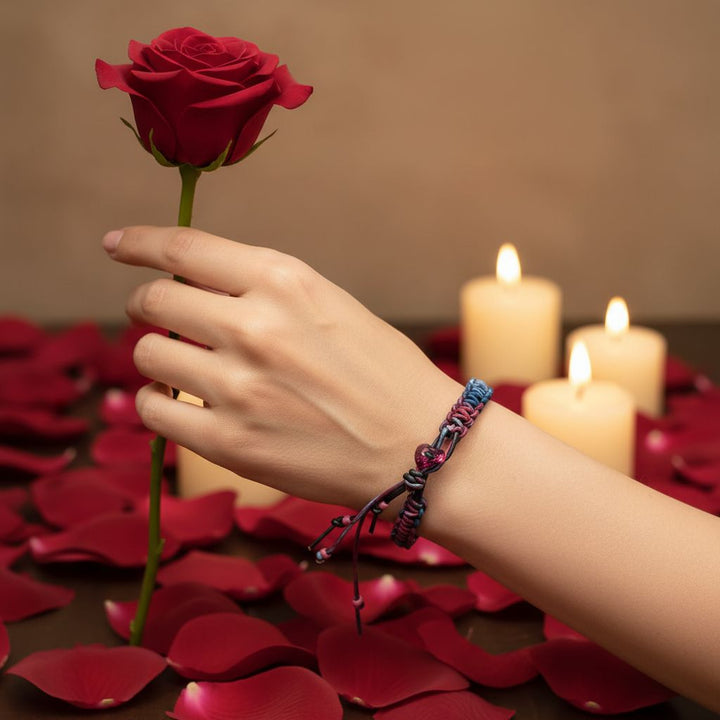 Person holding a rose while wearing a Macrame Tie-Dye Leather Crystal Bracelet beside lit candles and rose petals.