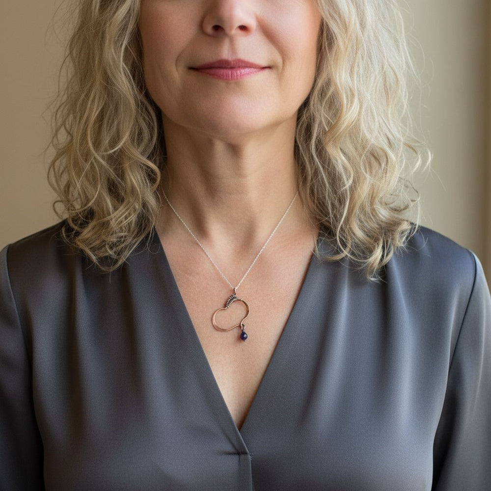 Hammered Copper Butterfly Wing Child Abuse Survivor Necklace worn by a woman with curly blonde hair.