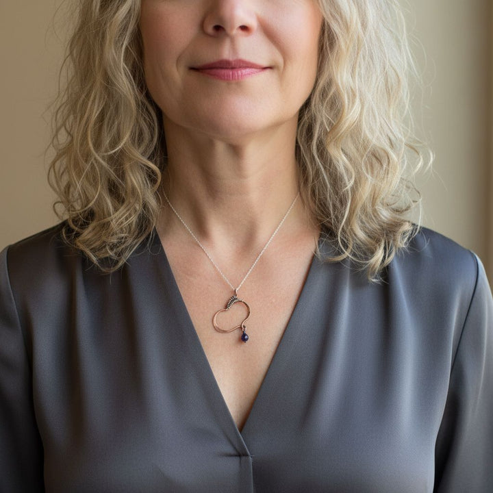 Hammered Copper Butterfly Wing Child Abuse Survivor Necklace worn by a woman with curly blonde hair.