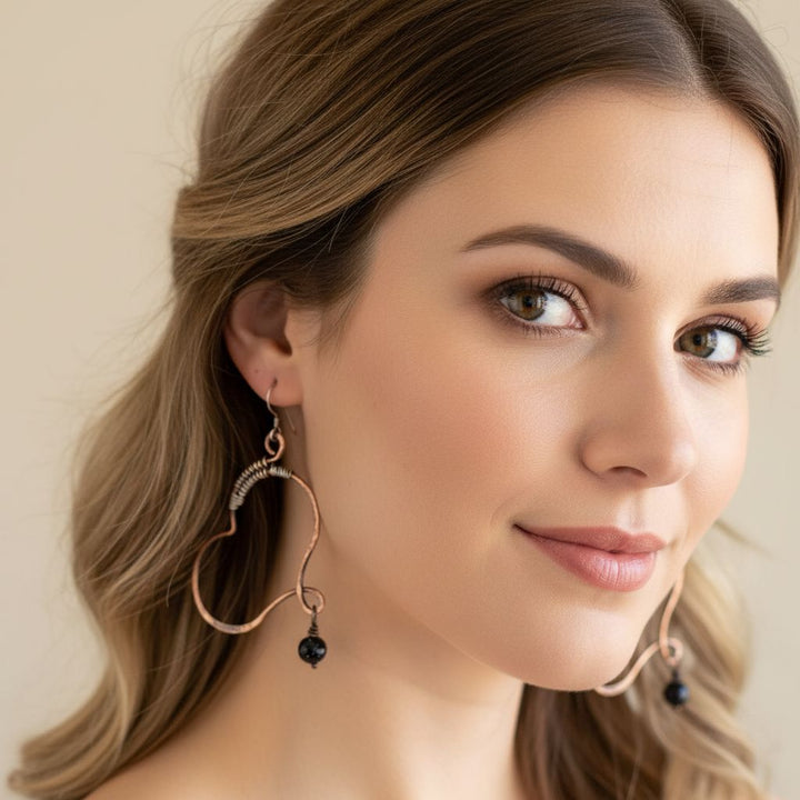 Model wearing Sculpted Copper Butterfly Wing Abuse Survivor Earrings with black Swarovski crystal dangles.