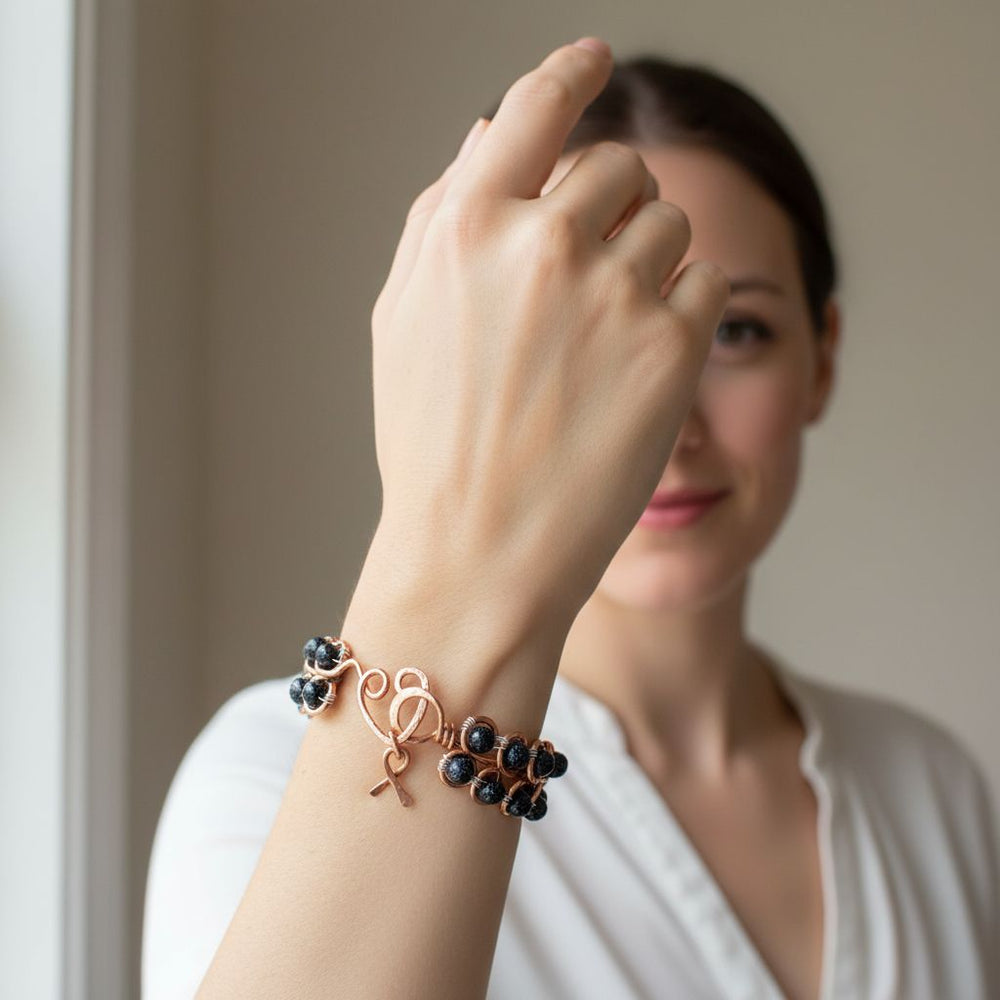 Wire Sculpted Blue Beaded Infinity Child Abuse Bangle worn by a model showcasing its beauty and significance.