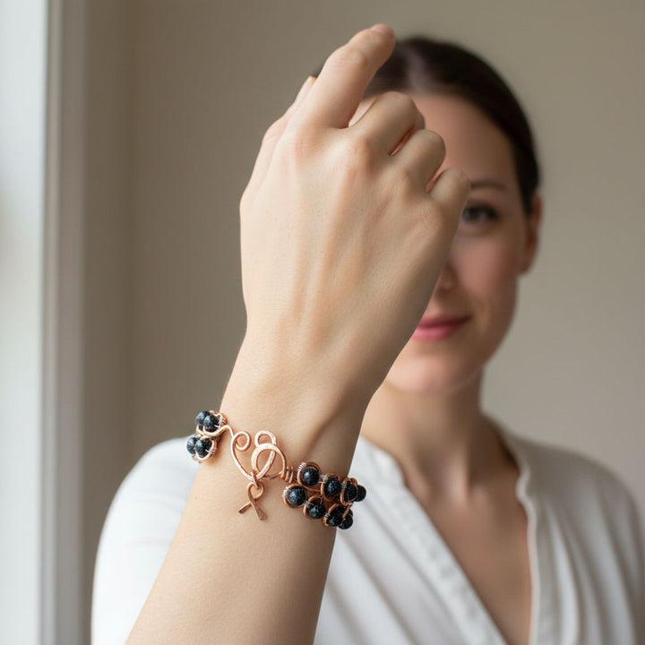 Wire Sculpted Blue Beaded Infinity Child Abuse Bangle worn by a model showcasing its beauty and significance.