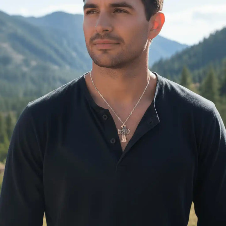 Chained Hammered Copper Cross Necklace For Him Or Her worn by a man outdoors with mountains in the background.
