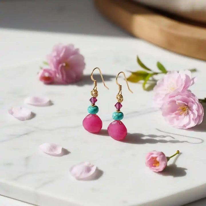 Gold Filled Wire Wrapped Pink And Aqua Gemstone Earrings with pink and aqua gemstones on a marble surface.