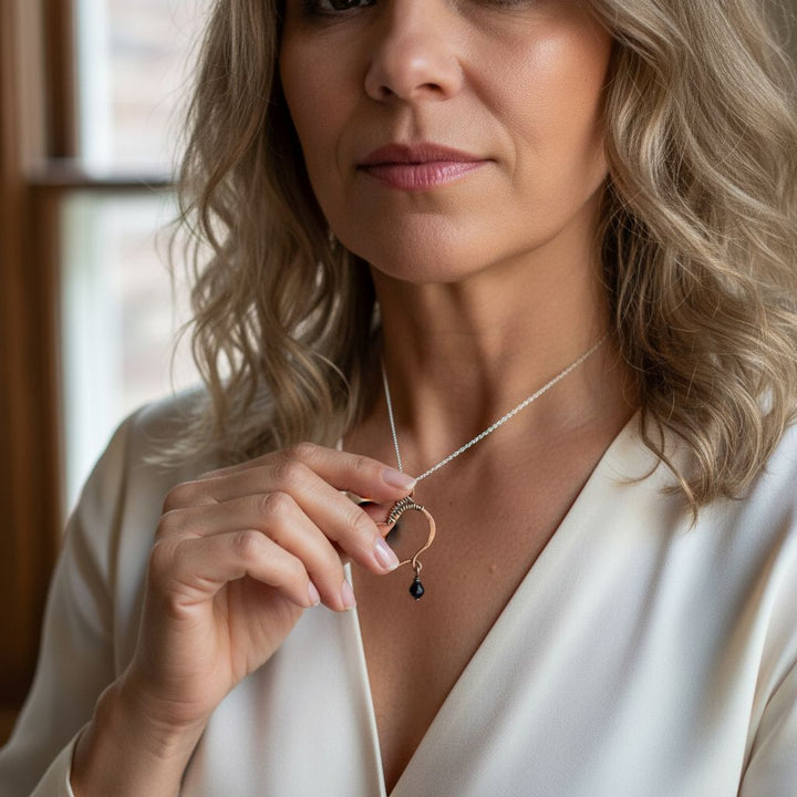 Woman wearing a Hammered Copper Butterfly Wing Child Abuse Survivor Necklace with black Swarovski crystal.