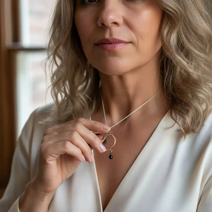Woman wearing a Hammered Copper Butterfly Wing Child Abuse Survivor Necklace with black Swarovski crystal.