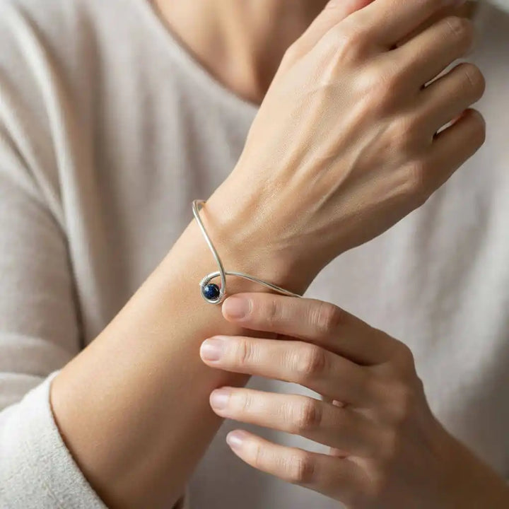 Silver Blue Bead Child Abuse Awareness Ribbon Bangle worn on a woman&
