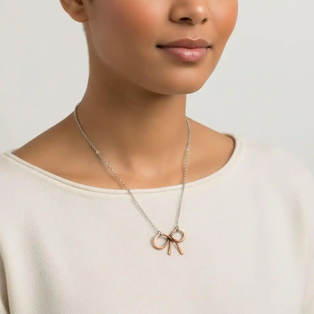 Model wearing a Wire Wrapped Copper Bow Tie Silver Chain Necklace with a hand-sculpted copper pendant.