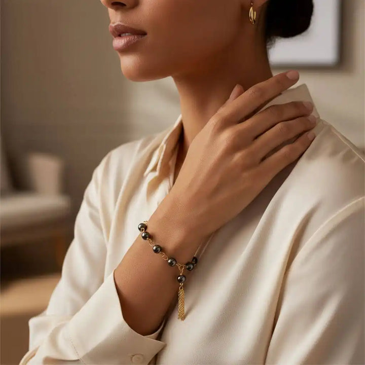 Adjustable 14 KT Gold Filled Hematite Chain Tassel Bracelet worn by a woman, showcasing its elegance on her wrist.